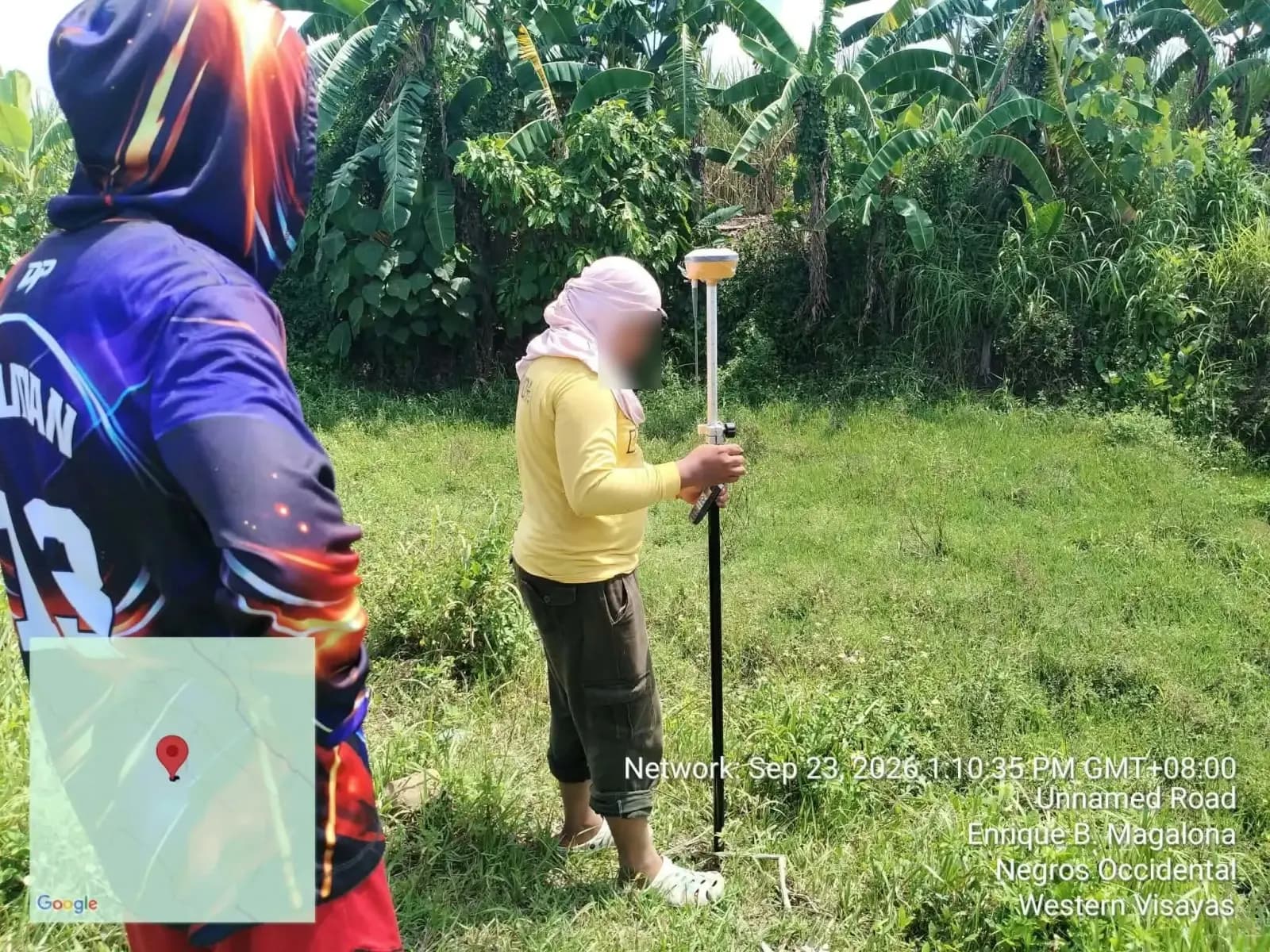 A person holding a GNSS receiver and controller in a grassy clearing during the relocation survey