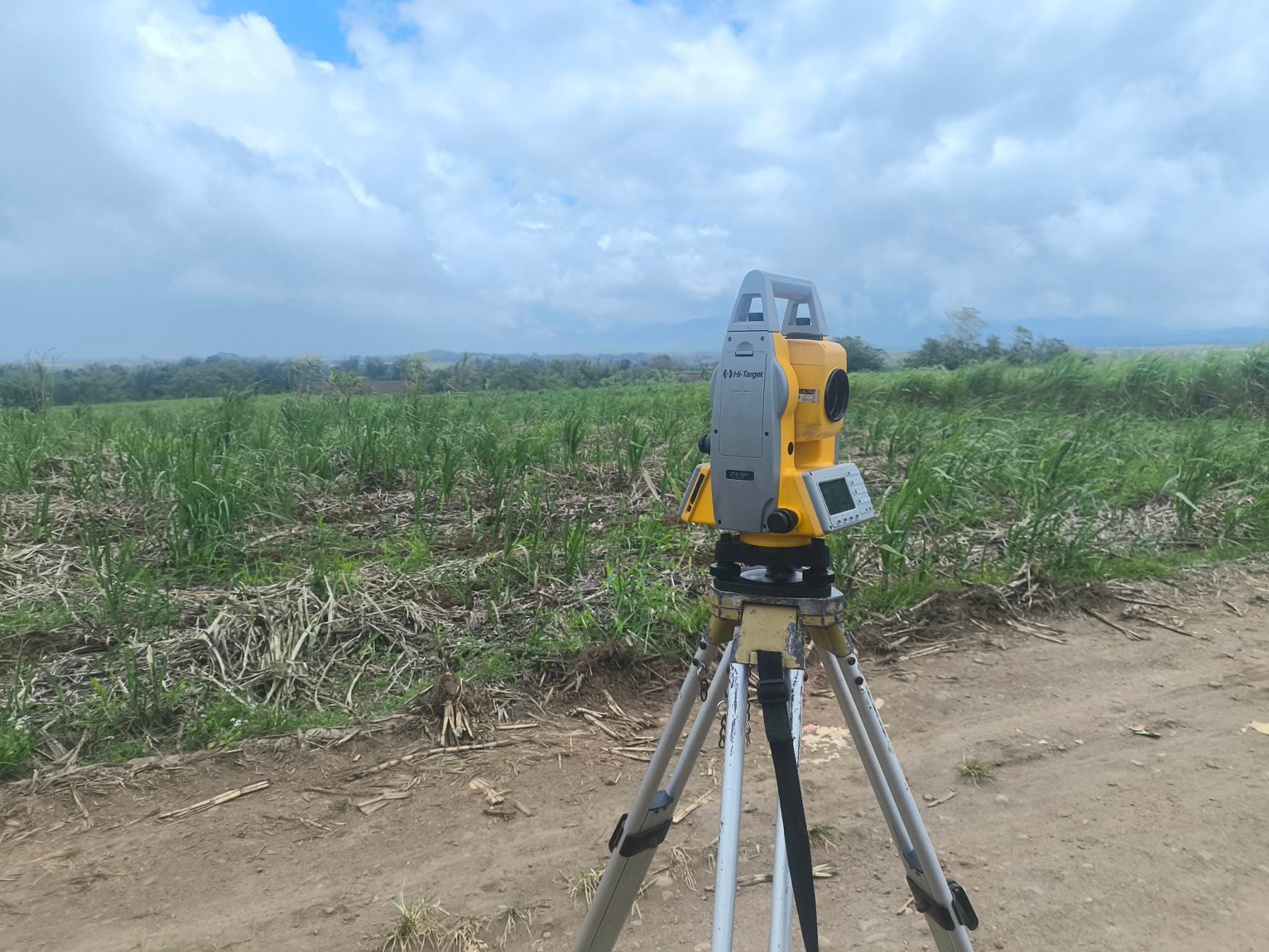 Survey equipment set up on open farmland during a lot consolidation survey